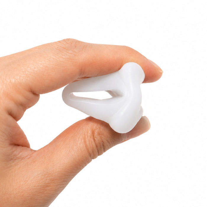 A hand holding a small, white, silicone-like curved ring or loop